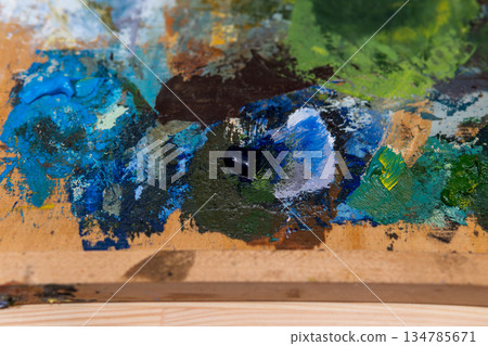 Colorful Paint Palette on Wooden Studio Palette with Blues, Greens, and Browns Colorful Paint Palette on Wooden Studio Palette with Blues, Greens, and Browns 134785671