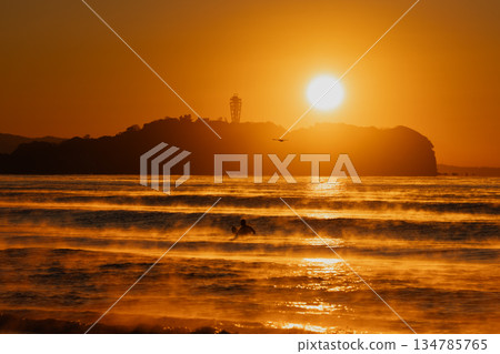 清晨的陽光照耀著茅崎的大海,衝浪者們在海面上馳騁。 清晨的陽光照耀著茅崎的大海,衝浪者們在海面上馳騁。 134785765