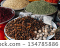 A vibrant and aromatic display of various spices, including star anise, nutmeg, and colorful ground herbs, arranged in large bowls and small bags. This image showcases the rich culinary traditions of 134785886