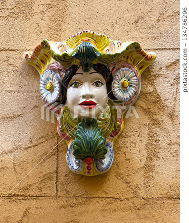 Ornate ceramic moor's head mask decorating a sicilian wall 134786296