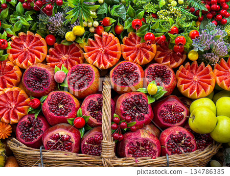 Fresh pomegranates and citrus slices in woven basket Fresh pomegranates and citrus slices in woven basket 134786385