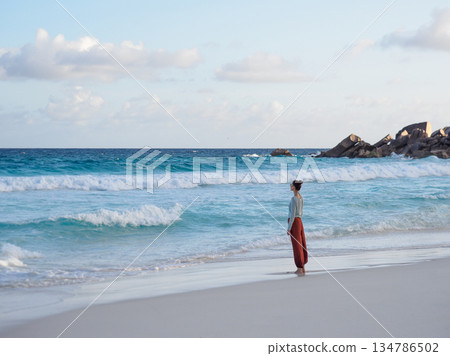 Cute woman walking on stunning white sand beach Cute woman walking on stunning white sand beach 134786502