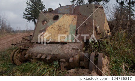rusting armored hull rests in field, camouflage paint flaking, missing tracks and exposed rivets, moss rusting armored hull rests in field, camouflage paint flaking, missing tracks and exposed rivets, moss 134786817