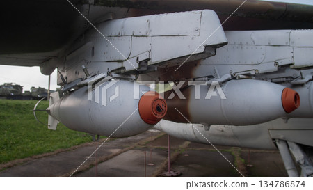 weapon bay pylon detail with attached tanks and open access panels, tethered safety ropes and damp grass weapon bay pylon detail with attached tanks and open access panels, tethered safety ropes and damp grass 134786874
