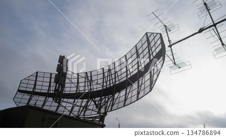 curved radar panel silhouette scanning horizon, ground surveillance and detection mood with large reflector 134786894