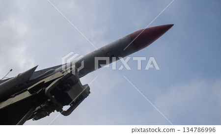 red nosed missile angled toward sky with launcher mechanism visible, closeup of seeker tip and aerodynamic red nosed missile angled toward sky with launcher mechanism visible, closeup of seeker tip and aerodynamic 134786996