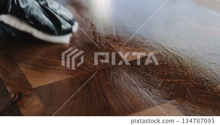 woodworker applying oil finish to walnut end grain wood board 134787091