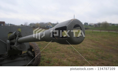 closeup of weathered steel, shot highlighting bore and vent openings vividly, close examination emphasizing rough steel surface with interior openings against cloudy landscape background 134787109