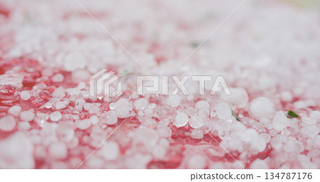 closeup of hailstones on red car after strong hailstorm 134787176