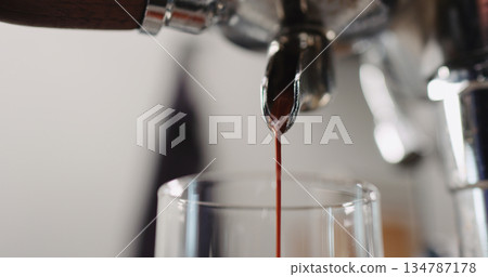 Low angle shot of espresso pour from coffee machine ingo glass cup Low angle shot of espresso pour from coffee machine ingo glass cup 134787178