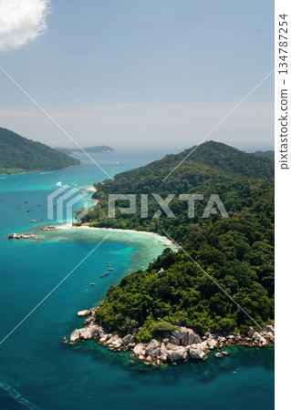 Stunning aerial view of a tropical island with lush greenery and clear waters on a bright sunny day in the Perhentian Islands. Malaysia Stunning aerial view of a tropical island with lush greenery and clear waters on a bright sunny day in the Perhentian Islands. Malaysia 134787254