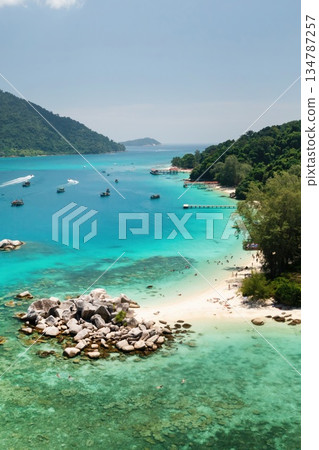 Breathtaking view of a secluded beach with crystal clear waters and rocky formations on the Perhentian islands. Malaysia Breathtaking view of a secluded beach with crystal clear waters and rocky formations on the Perhentian islands. Malaysia 134787257