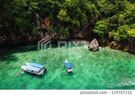 A group of tourists are snorkeling in Kilim Geopark near Langkawi Island. Boats with tourists in Kilim Park . Malaysia 134787310