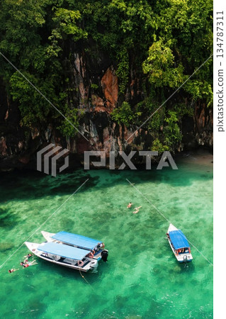 A group of tourists are snorkeling in Kilim Geopark near Langkawi Island. Boats with tourists in Kilim Park . Malaysia 134787311