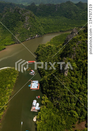 Aerial view of the fish farm in Kilim Geopark, surrounded by lush green mountains, with boats, Langkawi Island. Malaysia Aerial view of the fish farm in Kilim Geopark, surrounded by lush green mountains, with boats, Langkawi Island. Malaysia 134787319