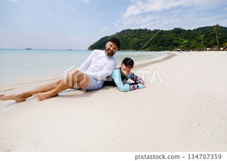 A couple is relaxing on turtle beach on a sunny day on Redang Island. Malaysia A couple is relaxing on turtle beach on a sunny day on Redang Island. Malaysia 134787359