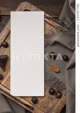 Vertical card on wooden tray near brown decor and grey linen cloth top view, boho mockup Vertical card on wooden tray near brown decor and grey linen cloth top view, boho mockup 134787766