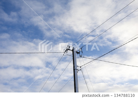 Utility pole with power lines against cloudy sky in daylight Utility pole with power lines against cloudy sky in daylight 134788110
