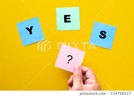 Hand holding question mark choosing between yes notes 134788527