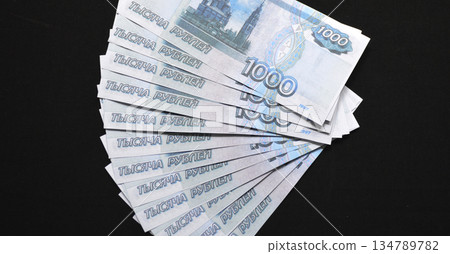 a pack of Russian rubles laid out on a black background 134789782