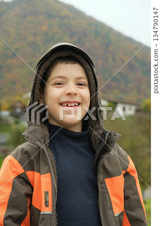 Portrait of happy 8 year old child in hooded jacket in autumn mountains. Portrait of happy 8 year old child in hooded jacket in autumn mountains. 134790147