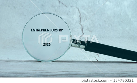 A magnifying glass focuses sharply on the word Entrepreneurship and the year 2026, resting on a textured surface, symbolizing a view into future opportunities A magnifying glass focuses sharply on the word Entrepreneurship and the year 2026, resting on a textured surface, symbolizing a view into future opportunities 134790321