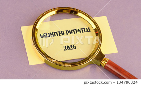A golden magnifying glass zooms in on a pale yellow note card displaying the phrase UNLIMITED POTENTIAL and the year 2026 against a serene lilac backdrop, hinting at prospects A golden magnifying glass zooms in on a pale yellow note card displaying the phrase UNLIMITED POTENTIAL and the year 2026 against a serene lilac backdrop, hinting at prospects 134790324