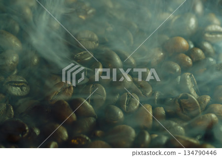 Close-up of roasted coffee beans with soft steam and haze, dramatic warm lighting, rich texture background for cafe and gourmet themes Close-up of roasted coffee beans with soft steam and haze, dramatic warm lighting, rich texture background for cafe and gourmet themes 134790446