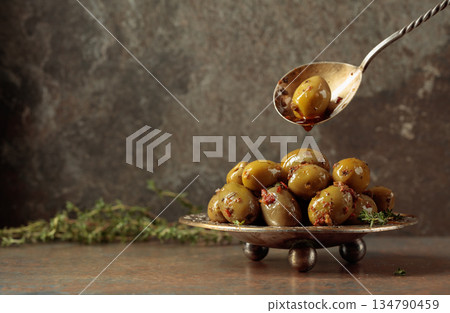 Spicy green olives are poured with olive oil with spices. Spicy green olives are poured with olive oil with spices. 134790459