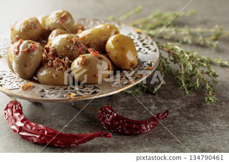 Spicy green olives in olive oil. Spicy green olives in olive oil. 134790461