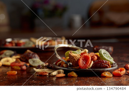 Dried tropical fruits, nuts, and raisins on a kitchen table. Dried tropical fruits, nuts, and raisins on a kitchen table. 134790484