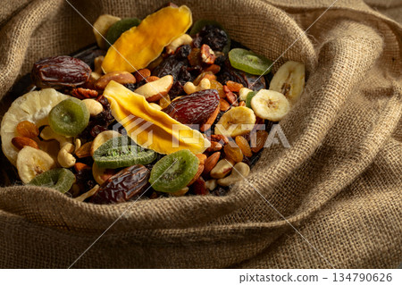 Dried tropical fruits and nuts in burlap bag. Dried tropical fruits and nuts in burlap bag. 134790626