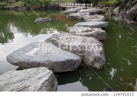 A beautiful Japanese garden with stepping stones and water surface in the pond at Kiyosumi Gardens A beautiful Japanese garden with stepping stones and water surface in the pond at Kiyosumi Gardens 134791015