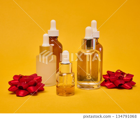 Various glass bottles with pipettes containing cosmetic serums or oils. 134791068