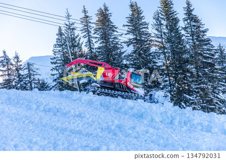 Red Snow Groomer Working on Mountain Slope in Winter Red Snow Groomer Working on Mountain Slope in Winter 134792031