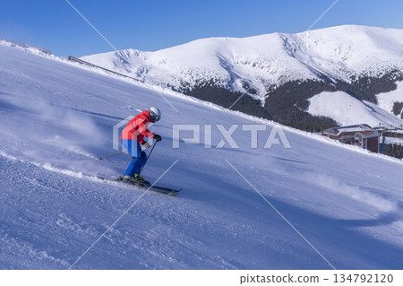 Active Skier Downhill Racing on Snowy Mountain Slope Active Skier Downhill Racing on Snowy Mountain Slope 134792120