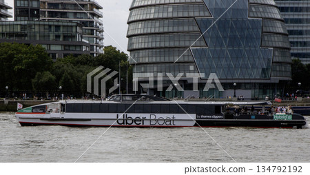 An Uber Boat Travels Along the River With Modern Buildings in Background An Uber Boat Travels Along the River With Modern Buildings in Background 134792192
