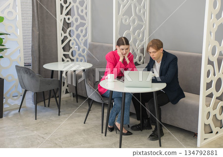 Colleagues are sitting at a laptop and discussing work.  134792881