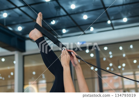 Caucasian woman doing exercises on reformer machine. Caucasian woman doing exercises on reformer machine. 134793019