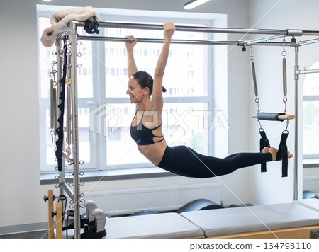 Caucasian woman doing pilates on reformer.  134793110