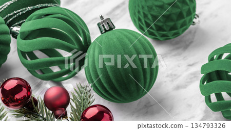 Green velvet baubles, Christmas ball ornaments and pine branches on marble table Green velvet baubles, Christmas ball ornaments and pine branches on marble table 134793326