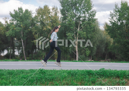 Caucasian woman roller skating in park.  134793335