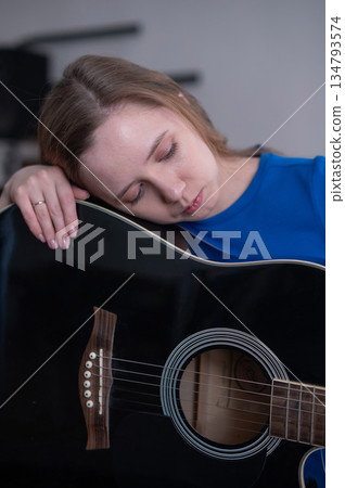 Young woman playing guitar in recording studio.  134793574