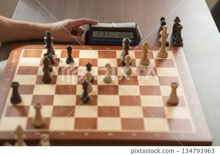 Close up of hands of middle aged caucasian man playing chess.  134793963