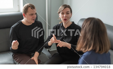 A man and two women are talking in Russian sign language. A man and two women are talking in Russian sign language. 134794018