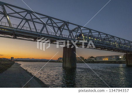 A photo of the Keio Line railway bridge over the Tama River at sunset 134794357
