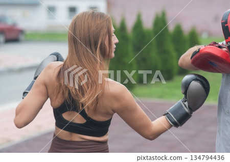 Man and woman sparring outdoors. Boxing lesson. Man and woman sparring outdoors. Boxing lesson. 134794436