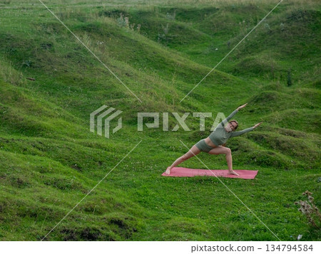 Caucasian woman doing yoga outdoors.  134794584