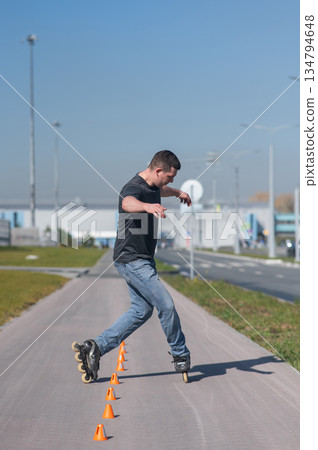 A Caucasian man rollerblades around the slalom course. A Caucasian man rollerblades around the slalom course. 134794648