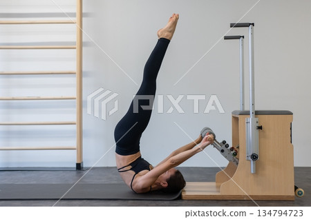 Caucasian woman doing Pilates on classic chair. 134794723